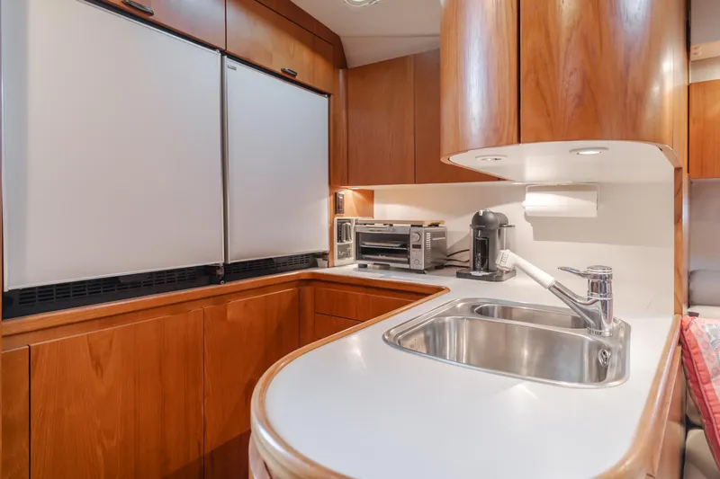 Miss Michelle Yacht Photos Pics 1996 Tiara Yachts 4300 kitchen with wood cabinets, sink, and appliances.