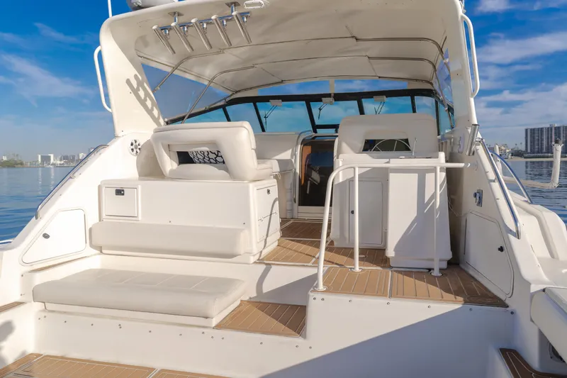 Miss Michelle Yacht Photos Pics 1996 Tiara Yachts 4300 boat interior with seating and helm, under clear blue sky.