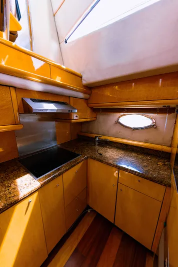La More Yacht Photos Pics Luxurious kitchen interior of 2004 Sunseeker Manhattan 60 yacht with wooden cabinetry and granite countertops.