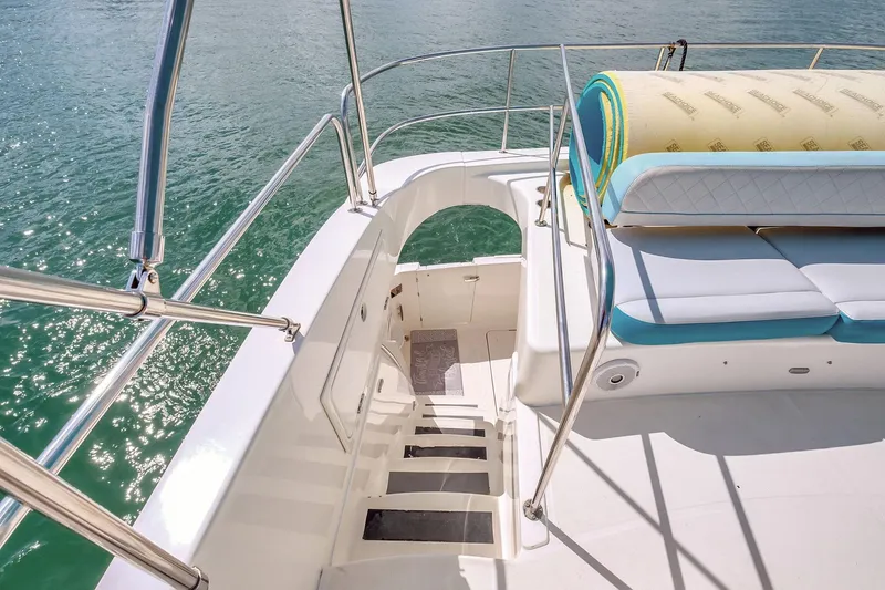  Yacht Photos Pics 2016 Silverton 43SB yacht deck with stairs, railing, and cushioned seating by the water.
