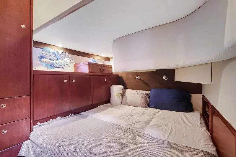  Yacht Photos Pics Cozy bedroom in 2016 Silverton 43SB yacht with wooden cabinets and soft lighting.