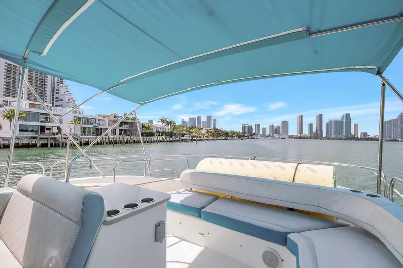  Yacht Photos Pics 2016 Silverton 43SB yacht with blue canopy, city skyline view, and waterfront homes.
