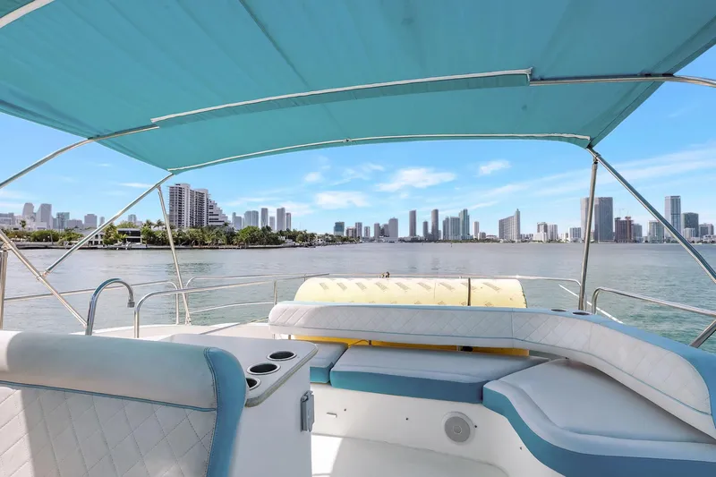  Yacht Photos Pics 2016 Silverton 43SB yacht with city skyline view under blue canopy.