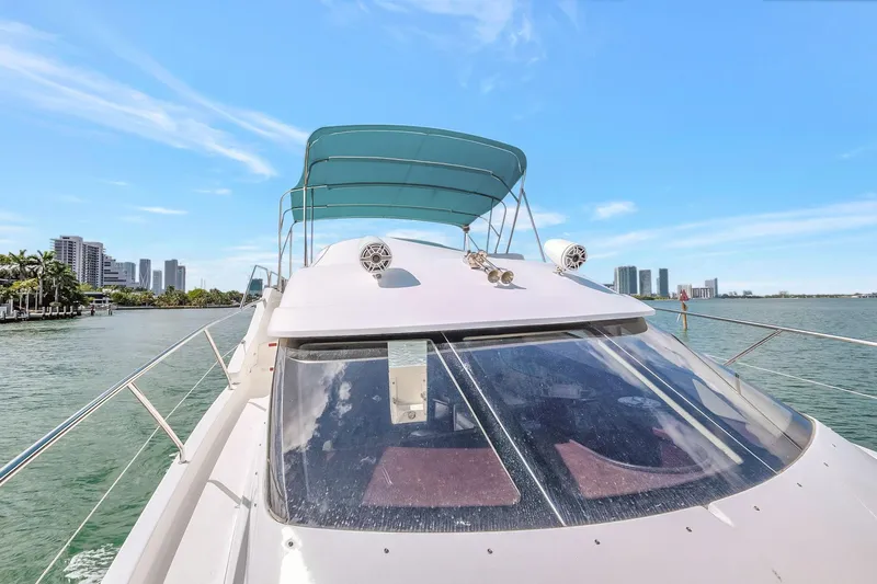  Yacht Photos Pics 2016 Silverton 43SB yacht cruising on a sunny day with city skyline in background.