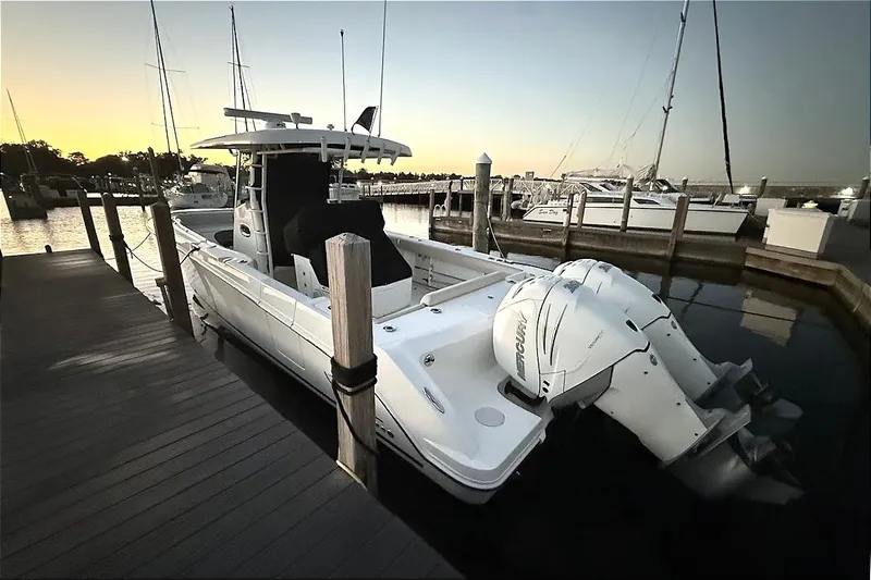  Yacht Photos Pics 2019 Boston Whaler 330 Outrage docked at sunset, featuring twin outboard engines.