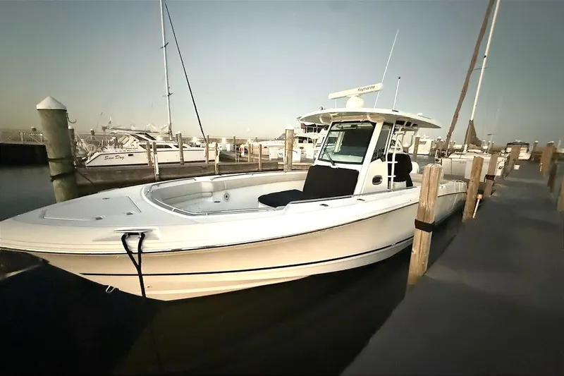 Yacht Photos Pics 2019 Boston Whaler 330 Outrage docked at marina, showcasing sleek design and spacious deck.