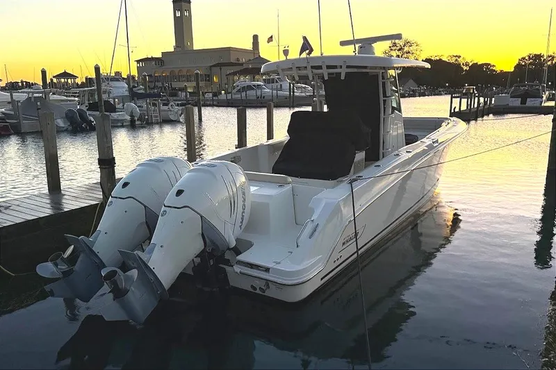  Yacht Photos Pics 2019 Boston Whaler 330 Outrage docked at sunset, featuring dual outboard engines.