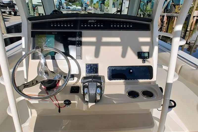  Yacht Photos Pics 2019 Boston Whaler 330 Outrage helm with steering wheel, controls, and navigation display.