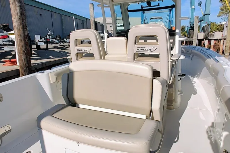 Yacht Photos Pics 2019 Boston Whaler 330 Outrage boat interior with beige seating and helm station.