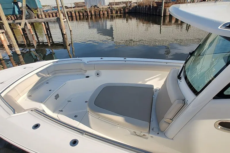 Yacht Photos Pics 2019 Boston Whaler 330 Outrage boat interior with seating, docked by calm water.