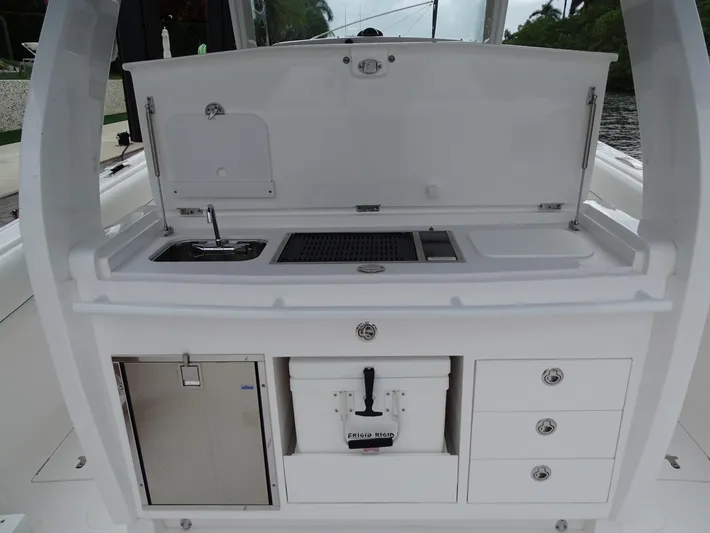  Yacht Photos Pics 2022 Intrepid 407 Panacea boat kitchen with sink, storage, and cooler.