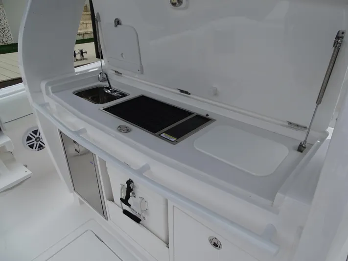  Yacht Photos Pics 2022 Intrepid 407 Panacea boat kitchen area with sink and storage compartments.