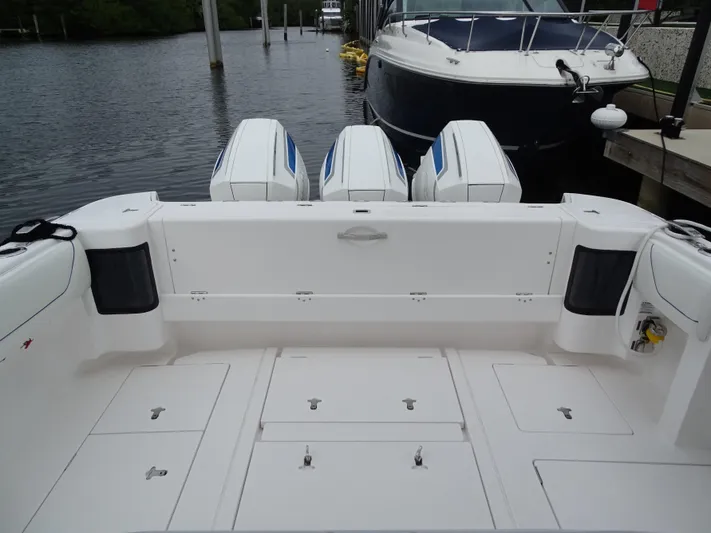  Yacht Photos Pics 2022 Intrepid 407 Panacea boat with triple outboard engines docked by the water.