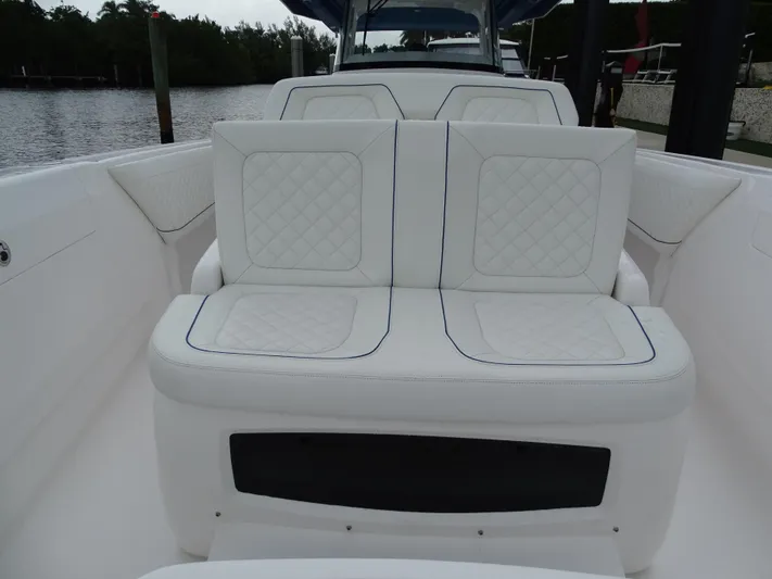  Yacht Photos Pics 2022 Intrepid 407 Panacea boat with white cushioned seating, docked by the water.