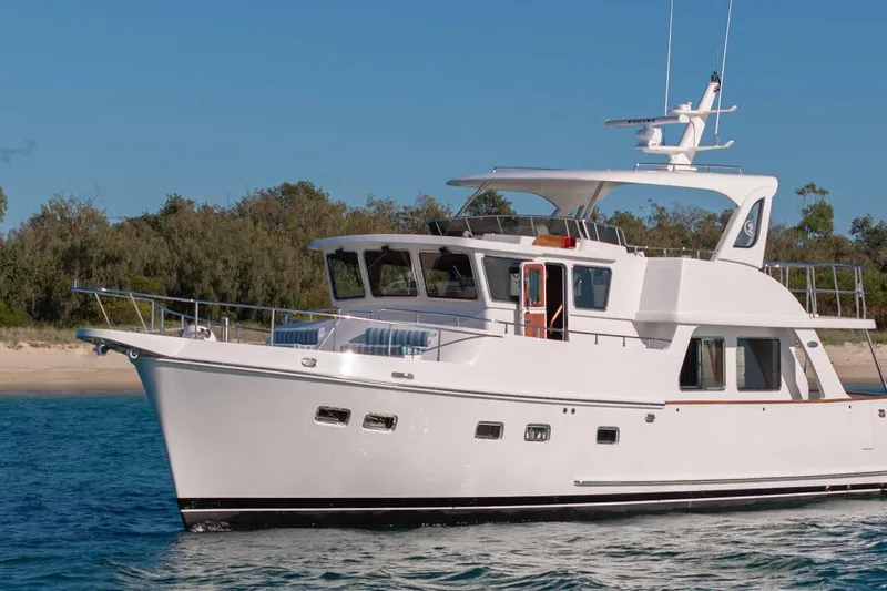  Yacht Photos Pics 2024 Selene 49 yacht cruising near a sandy shoreline under a clear blue sky.