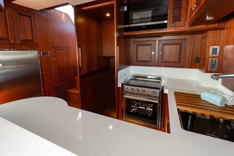  Yacht Photos Pics Luxurious 2024 Selene 49 yacht kitchen with modern appliances and elegant wood cabinetry.