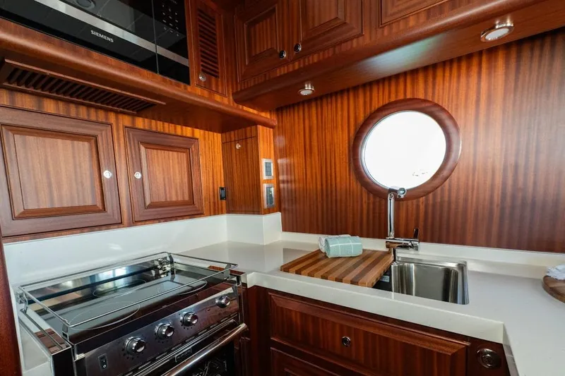  Yacht Photos Pics Luxurious 2024 Selene 49 yacht kitchen with wood cabinetry and stainless steel appliances.