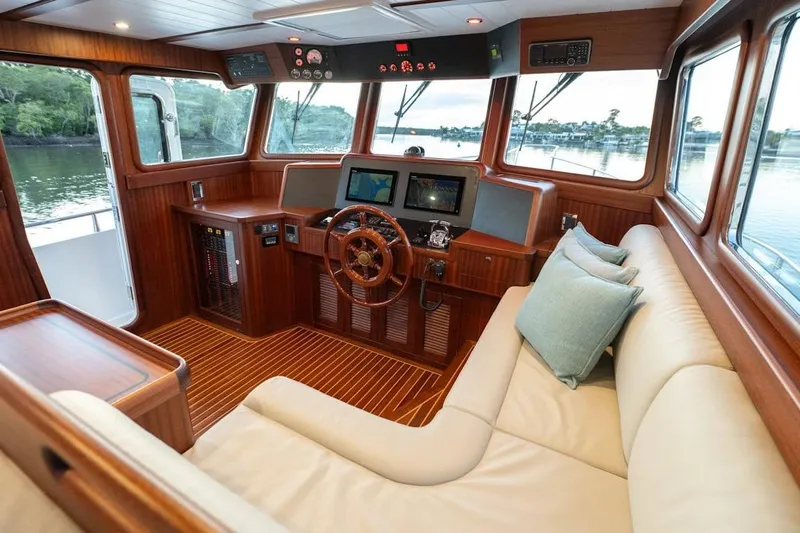  Yacht Photos Pics Luxurious 2024 Selene 49 yacht interior with wooden helm, plush seating, and navigation equipment.