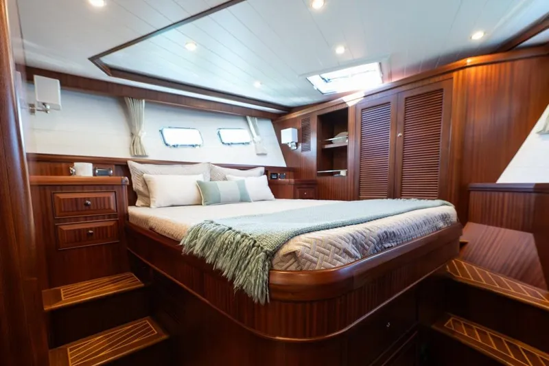  Yacht Photos Pics Luxurious cabin interior of 2024 Selene 49 yacht with wooden finishes and cozy bedding.