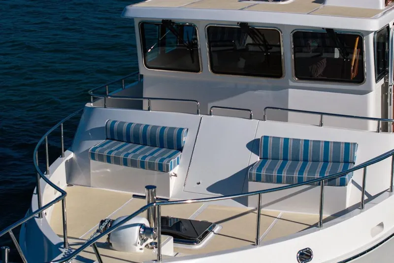  Yacht Photos Pics 2024 Selene 49 yacht with striped seating on deck, cruising on calm waters.