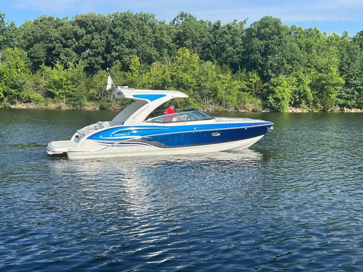  Yacht Photos Pics 2023 Formula 310 Bowrider I/O cruising on a serene lake with lush green trees.