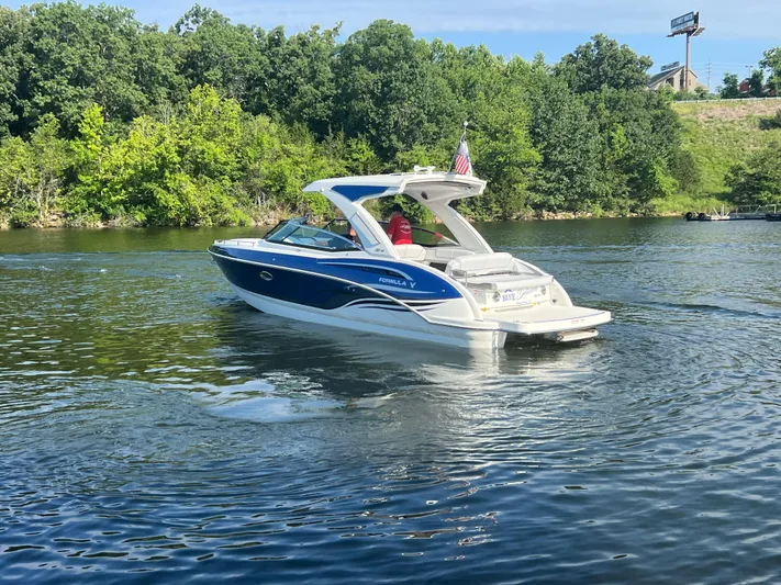  Yacht Photos Pics 2023 Formula 310 Bowrider I/O cruising on a scenic lake with lush green trees.