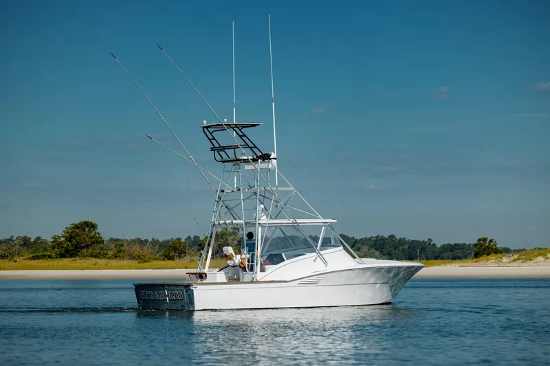 Nuts And Bolts Yacht Photos Pics 1998 Scopinich Custom Express boat on calm water with fishing rods.