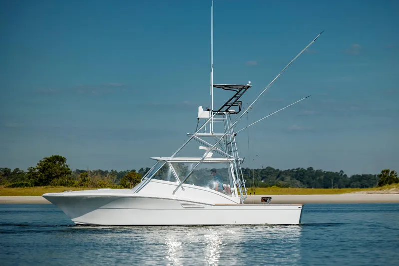 Nuts And Bolts Yacht Photos Pics 1998 Scopinich Custom Express boat cruising on calm water near a shoreline.