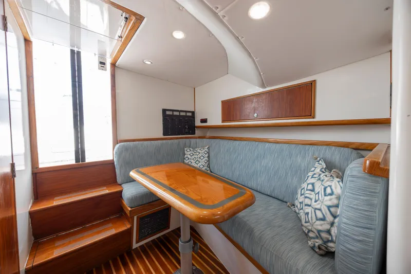 Nuts And Bolts Yacht Photos Pics 1998 Scopinich Custom Express interior with blue seating and wooden table.