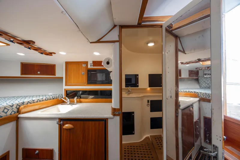 Nuts And Bolts Yacht Photos Pics 1998 Scopinich Custom Express boat interior with kitchenette and bathroom.