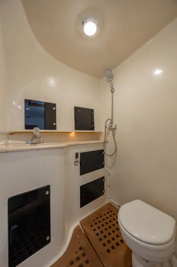 Nuts And Bolts Yacht Photos Pics 1998 Scopinich Custom Express boat bathroom with shower, toilet, and storage cabinets.