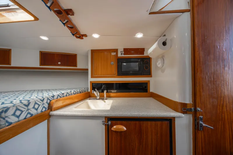 Nuts And Bolts Yacht Photos Pics 1998 Scopinich Custom Express boat interior with kitchenette and bed.