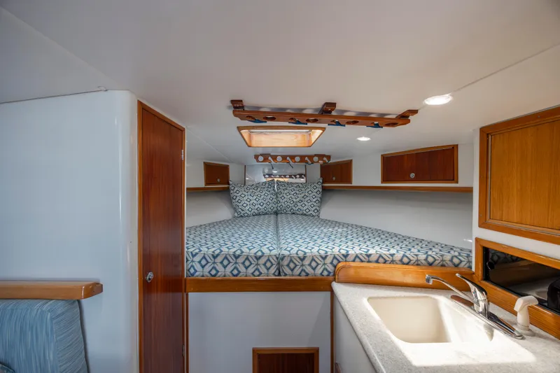Nuts And Bolts Yacht Photos Pics 1998 Scopinich Custom Express cabin interior with bed, sink, and wooden cabinets.