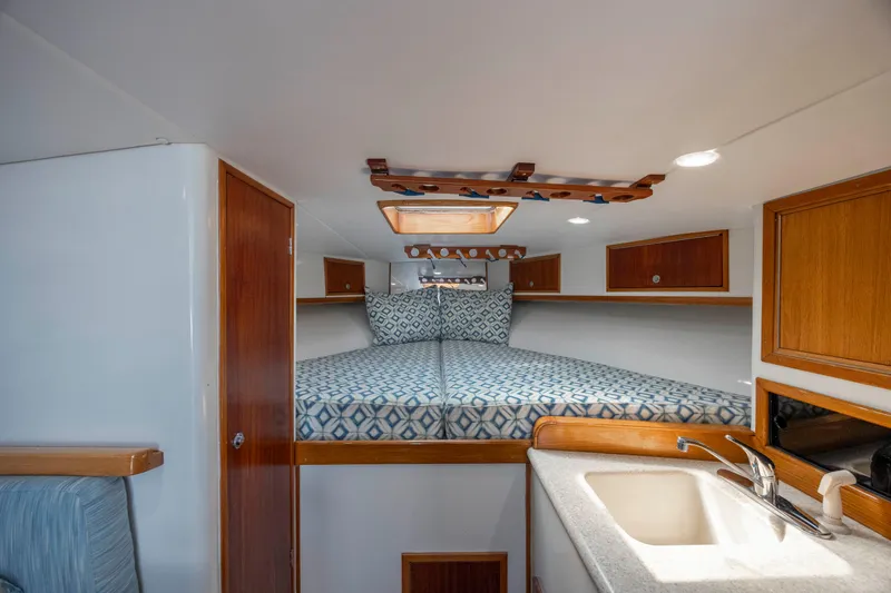 Nuts And Bolts Yacht Photos Pics 1998 Scopinich Custom Express cabin interior with bed, sink, and wooden cabinets.