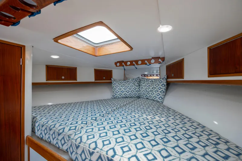 Nuts And Bolts Yacht Photos Pics 1998 Scopinich Custom Express cabin with patterned bedding and wooden storage cabinets.