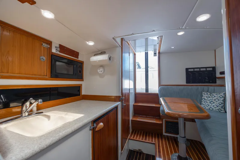 Nuts And Bolts Yacht Photos Pics 1998 Scopinich Custom Express boat interior with kitchenette, seating area, and stairs.