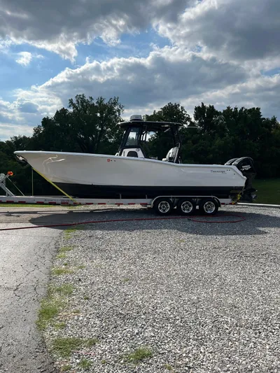 Floating Stones Yacht Photos Pics 2022 Tidewater 292 CC Adventure boat on trailer, parked outdoors under cloudy sky.