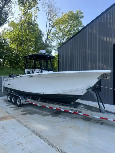 Floating Stones Yacht Photos Pics 2022 Tidewater 292 CC Adventure boat on trailer, parked near a building.