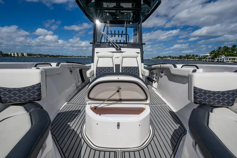 Floating Stones Yacht Photos Pics 2022 Tidewater 292 CC Adventure boat interior with seating and storage, on a sunny day.