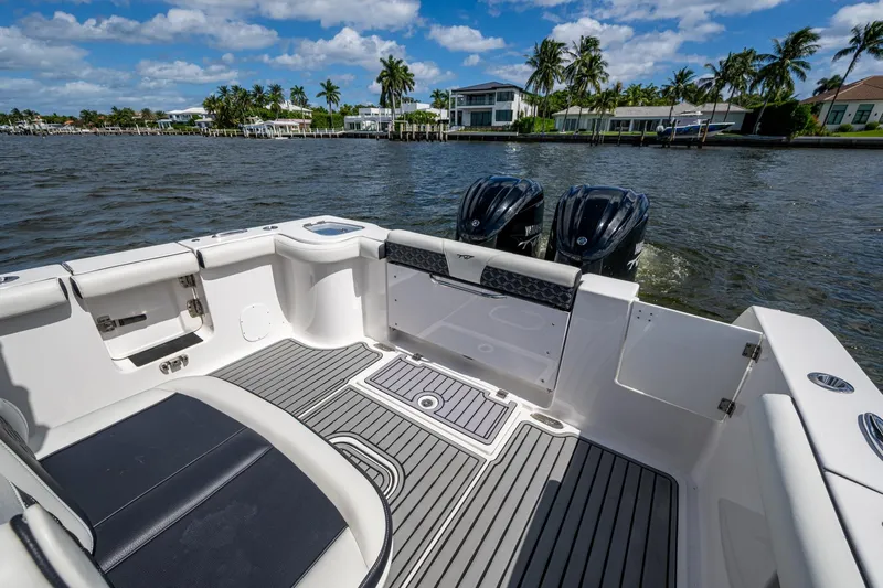 Floating Stones Yacht Photos Pics 2022 Tidewater 292 CC Adventure boat interior with twin engines, docked by waterfront homes.