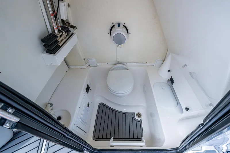 Floating Stones Yacht Photos Pics 2022 Tidewater 292 CC Adventure boat bathroom interior with toilet and storage compartments.