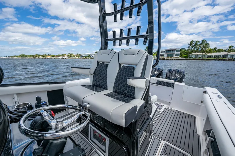 Floating Stones Yacht Photos Pics 2022 Tidewater 292 CC Adventure boat interior with dual seats and steering wheel.