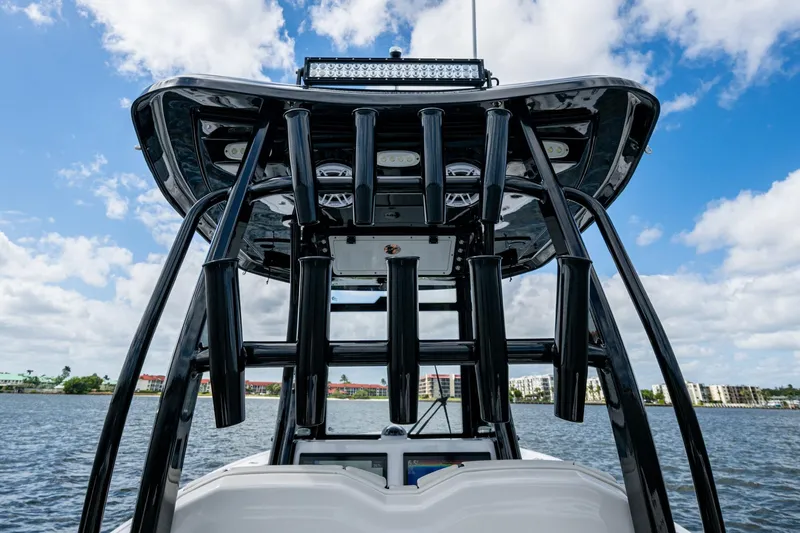 Floating Stones Yacht Photos Pics 2022 Tidewater 292 CC Adventure boat with rod holders, viewed from the rear on water.