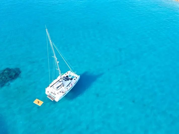 Buena Vida Yacht Photos Pics 2023 Lagoon 50 catamaran sailing on clear turquoise water.