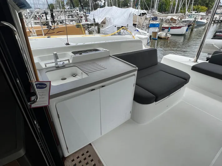 Buena Vida Yacht Photos Pics 2023 Lagoon 50 yacht cockpit with sink, seating, and marina view.