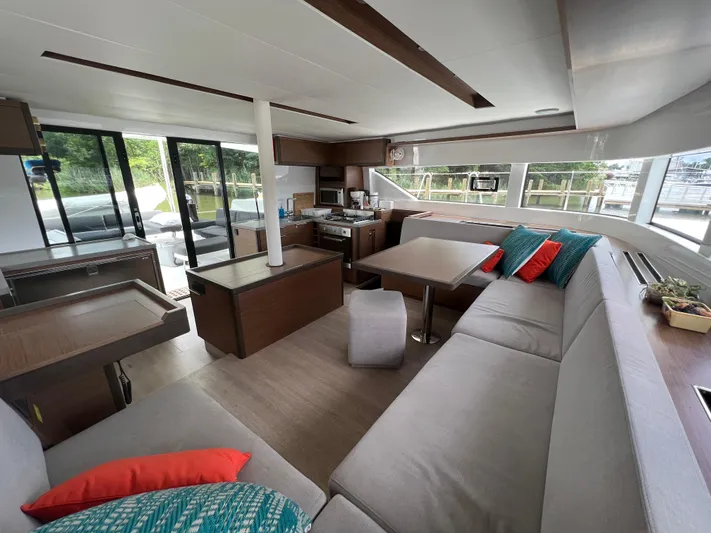 Buena Vida Yacht Photos Pics Luxurious interior of 2023 Lagoon 50 catamaran with modern seating and vibrant cushions.