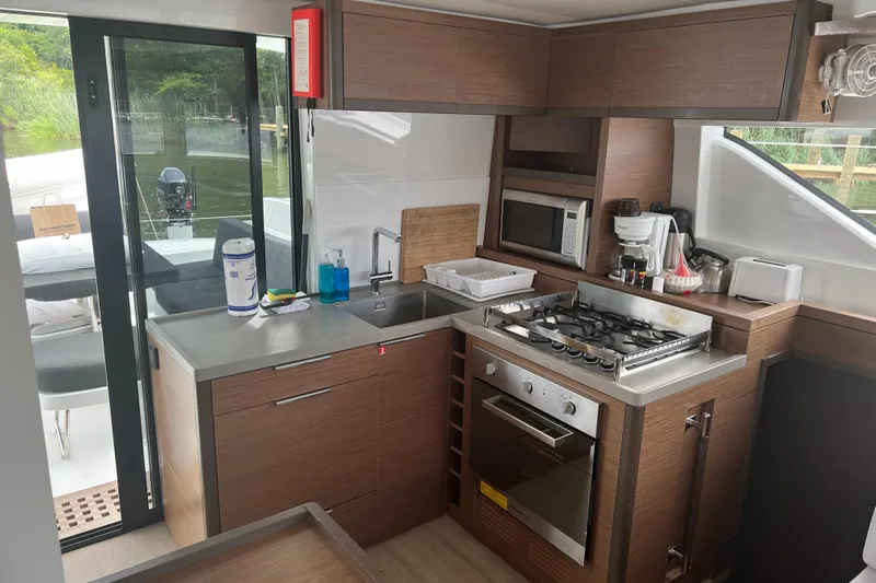 Buena Vida Yacht Photos Pics Modern kitchen interior on 2023 Lagoon 50 yacht, featuring stove, oven, and sleek cabinetry.