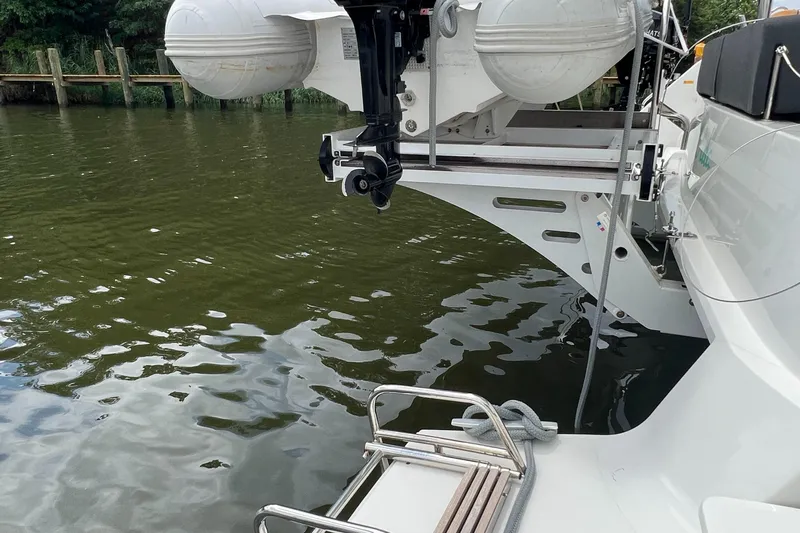 Buena Vida Yacht Photos Pics 2023 Lagoon 50 yacht stern with dinghy lift system on calm water.