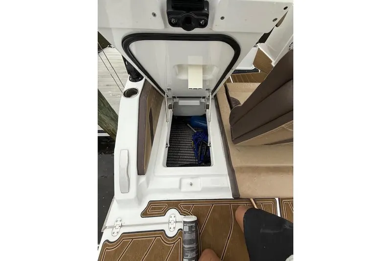  Yacht Photos Pics Open storage compartment on 2025 Monterey Elite 27 OB boat, featuring brown and white interior.