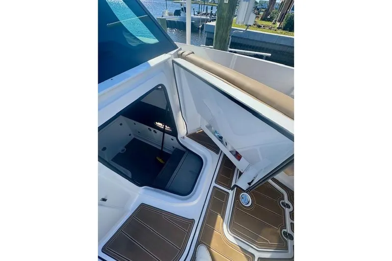  Yacht Photos Pics 2025 Monterey Elite 27 OB boat interior with open storage compartment and brown flooring.